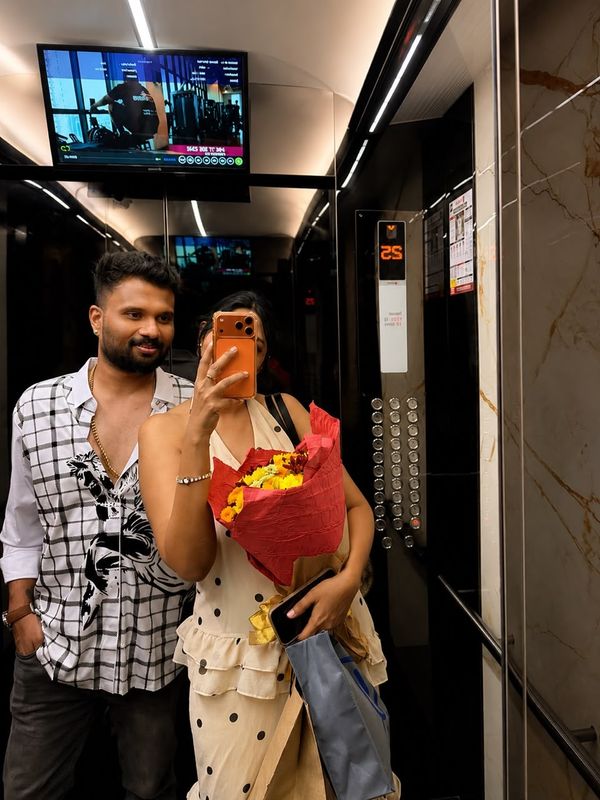 A mirror selfie in a lift, with flowers.